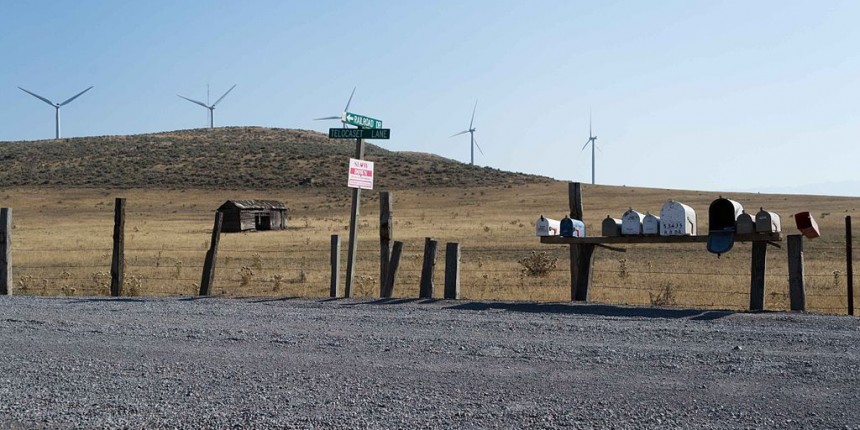A wind farm and mailboxes are visible across the gravel road in Telocaset, Oregon